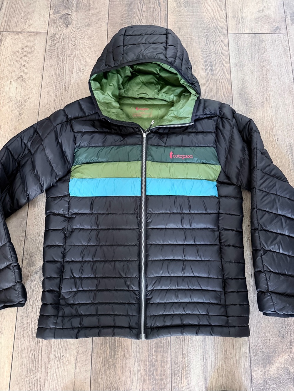 Cotopaxi Black Hooded Puffer with Green and Blue Chest Stripes